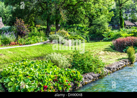 Der ziemlich Landschaftsgarten der Forellenzucht in Cotswold Dorf von Bibury in Coln Valley. Stockfoto