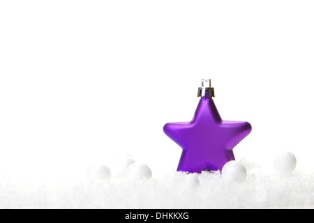 lila Weihnachtskugel als Weihnachtsstern auf Schnee Stockfoto