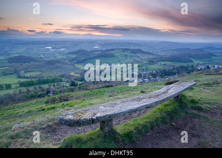 Eine alte verwitterte Holzbank auf der Westseite der Worcesteshire Leuchtturm, Malvern, bei Sonnenuntergang. Stockfoto