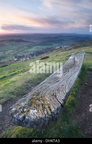 Eine alte verwitterte Holzbank auf der Westseite der Worcesteshire Leuchtturm, Malvern, bei Sonnenuntergang. Stockfoto