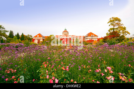 Das Hauptgebäude des Botanischen Gartens in München, mit Rosen, wilde Blumen und roten Blätter im herbstlichen Weitwinkel Stockfoto