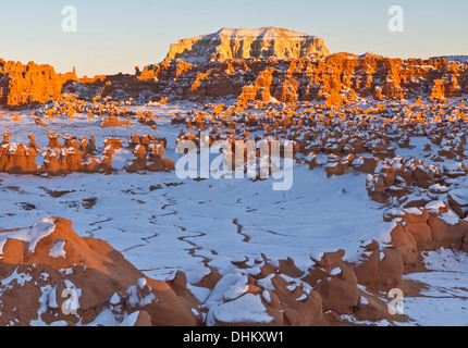 Späten Nachmittag Sonne trifft eine Reihe von seltsamen Felsformationen inmitten der Schnee im Goblin Valley State Park, Utah Stockfoto