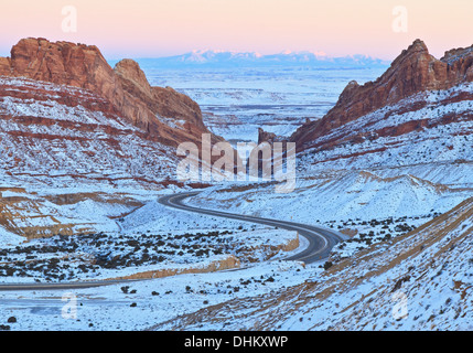 Interstate 70 Wind seinen Weg durch Schnee bedeckt Spotted Wolf Canyon durch die San Rafael Reef in Utah im Winter Stockfoto