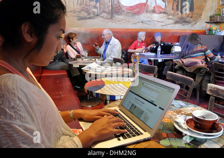 Frau, die auf Computer im Cafe Trieste in North Beach in San Francisco Stockfoto