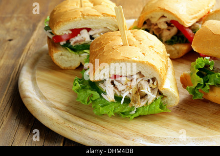 Panini-Sandwich mit Huhn und Gemüse auf einem Holzbrett Stockfoto