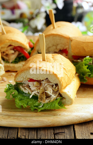 Panini-Sandwich mit Huhn und Gemüse auf einem Holzbrett Stockfoto