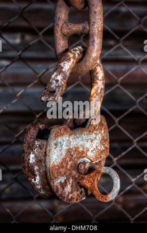 Großen altes rostigen Metall Vorhängeschloss mit Schlüssel an eine mutige Kette öffnen Stockfoto