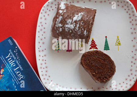 Marks & Spencer extrem schokoladig Yule Log zerschneiden auf festlichen Teller Stockfoto
