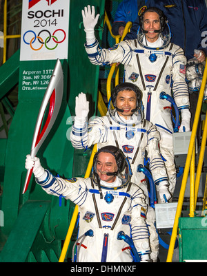 Internationale Raumstation ISS-Expedition 38 Sojus Commander Mikhail Tyurin von Roskosmos, halten die Olympische Fackel, Flight Engineer Koichi Wakata der Japan Aerospace Exploration Agency und Flugingenieur Rick Mastracchio der NASA oben, Welle Abschied vor dem Einstieg in der Sojus TMA - 11 M-Rakete zum Start 7. November 2013 am Weltraumbahnhof Baikonur, Kasachstan. Tyurin, Mastracchio, und Wakata verbringen die nächsten sechs Monate an Bord der internationalen Raumstation ISS. Stockfoto