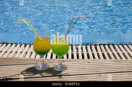 Gläser mit Cocktail am Rand des Pools Stockfoto