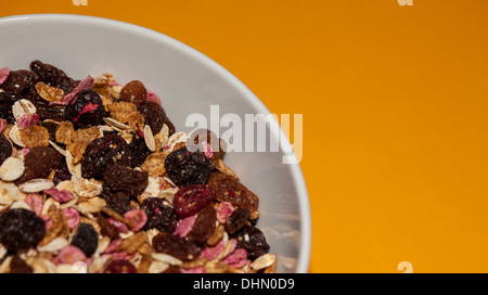 beschnitten, Schüssel Müsli auf einem orangefarbenen Hintergrund Stockfoto