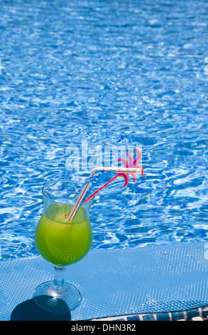 Glas-Ständer mit Cocktail am Rand des Pools Stockfoto