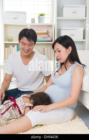 asiatische schwangere Mutter und ihre freche Tochter Stockfoto