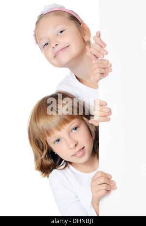 Kleines Mädchen spähen hinter der Anzeige Stockfoto