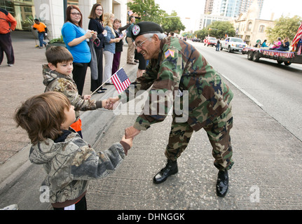 Vietnam männlichen Hispanic Kriegsveteran, grüßt, schüttelt Hände mit Publikum, Kinder während des Veteranen-Day-parade Stockfoto