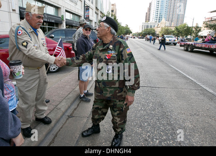 Vietnam männlichen Hispanic Kriegsveteran, grüßt, schüttelt Hände mit Publikum, Kinder während des Veteranen-Day-parade Stockfoto