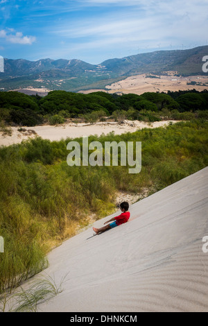 Junge, Schiebe die Sanddünen am Playa Valdevaqueros in Tarifa, Südspanien. Stockfoto