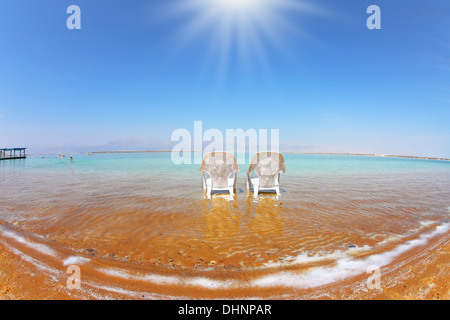 Zwei weiße Strand Sessel im Wasser Stockfoto