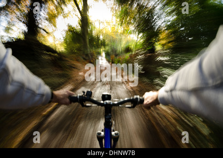 Blick über den Lenker entlang Baum gesäumt schlammigen Braut Weg Land Lane Steilufer schnell in Richtung Sonne Stockfoto