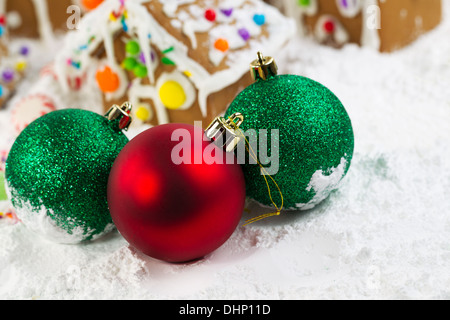 Closeup horizontale Foto von Weihnachtsschmuck mit Lebkuchenhäuser, umgeben von Pulverschnee im Hintergrund Stockfoto