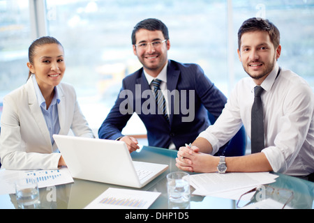Porträt von drei zuversichtlich Kollegen im Büro sitzen Stockfoto