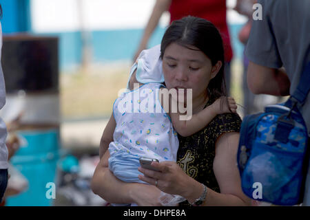 Cebu City, Philippinen. 14. November 2013. Evakuierten kommen auf C130 militärische Transportflugzeuge auf Mactan International Airport Cebu City.Most entstammen der Taifun am schwersten betroffenen Gebiete von Tacloban, Leyte und Guiuan, Eastern Samar. Alle haben ihre eigenen individuellen Geschichten wie sie es geschafft, der Taifun Wildheit zu überleben. Eine Empfangsstation Basis innerhalb des Flughafens ermöglicht Familien und Einzelpersonen zum Ausruhen, Nahrung und Wasser zu erhalten und vor allem kontaktieren verliebten. Bildnachweis: imagegallery2/Alamy Live-Nachrichten Stockfoto