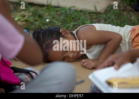 Cebu City, Philippinen. 14. November 2013. Dieses junge Mädchen liegt nun in einer Empfangsstation für evakuierte. Nach ihrer Mutter sie Form Fieber leidet aber vor allem haben Zugang zu Medizin an der Station. Die meisten wurden durch C130 Militärflugzeuge aus den am schlimmsten betroffenen Gebieten von Tacloban, Leyte oder Guiuan, Eastern Samar befördert. Bildnachweis: imagegallery2/Alamy Live-Nachrichten Stockfoto