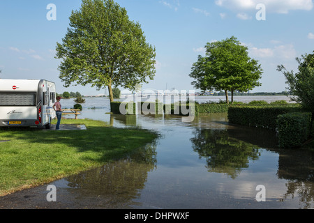 Niederlande, Slijk-Ewijk, Wohnwagen auf Campingplatz in den Überschwemmungsgebieten des Flusses Waal. Frau, die bei dem Hochwasser. Stockfoto