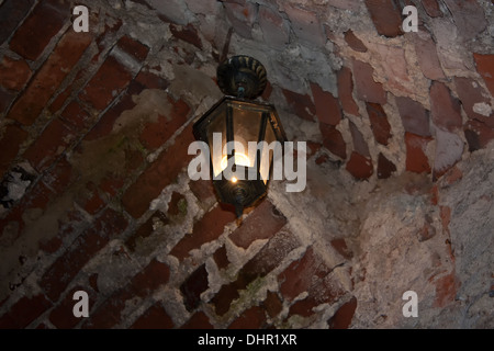 Alte rote Ziegel Wand und Licht an der Wand hängen. Dubno, Ukraine Stockfoto