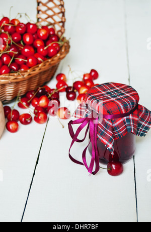 Glas mit Kirschen auf den weißen Holztisch Stockfoto