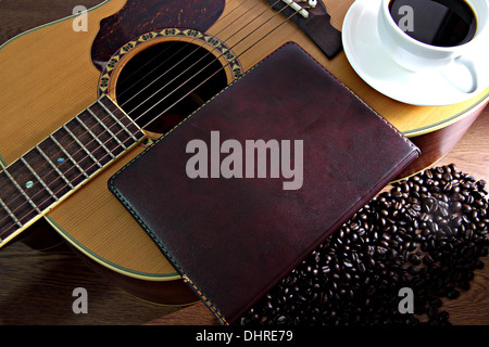 Die Konzepte, die weiße Kaffeetasse und alte Note Papier ruht auf der Gitarre. Stockfoto