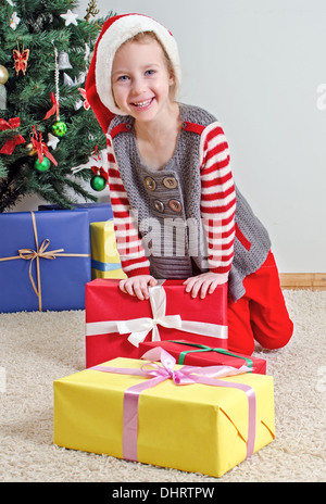 Glückliche kleine Mädchen im Weihnachtsmann-Kostüm Weihnachtsbaum. Stockfoto