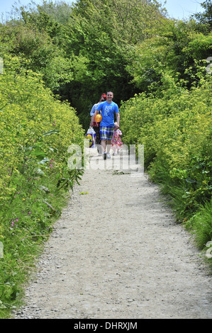 Familie Wandern im Frühjahr entlang Fußweg vom Dorf Croyde in Richtung Meer und Croyde Bay, Devon, England, Großbritannien Stockfoto