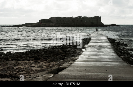 Mann, die Fischerei auf überfluteten Damm am Fort Ile de Raz, Alderney, Kanalinseln Stockfoto