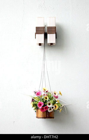 Bunte Blumen in einem hölzernen Korb und es hing. Stockfoto