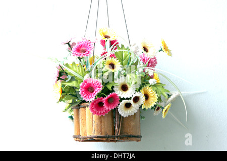 Bunte Blumen in einem hölzernen Korb und es hing. Stockfoto