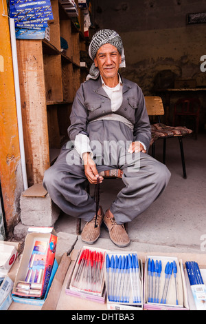 Kurdischen Mann in traditioneller Kleidung sitzt in seinem Geschäft in Erbil Nordirak Stockfoto