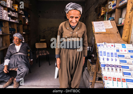 Zwei alte kurdische Männer in traditioneller Kleidung in einem Shop in Arbil, Irak Stockfoto