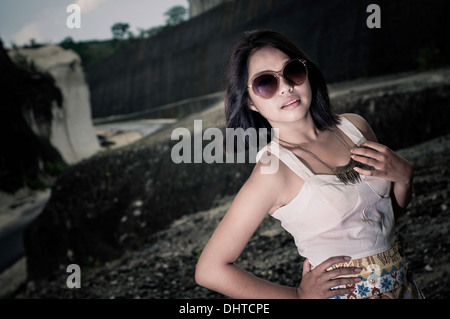 Eine glückliche junge Mode-Modell in eine energetische Pose, eine Brille und stand am Rande des Abgrunds. Stockfoto