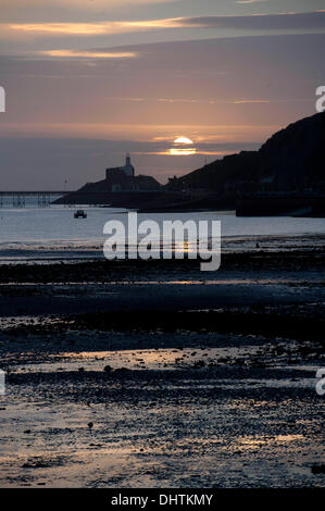 Swansea - UK 15. November 2013: die Sonne geht über den Leuchtturm am Mumbles auf einer klaren Herbstmorgen. Bildnachweis: Phil Rees/Alamy Live-Nachrichten Stockfoto