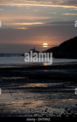 Swansea - UK 15. November 2013: die Sonne geht über den Leuchtturm am Mumbles auf einer klaren Herbstmorgen. Bildnachweis: Phil Rees/Alamy Live-Nachrichten Stockfoto