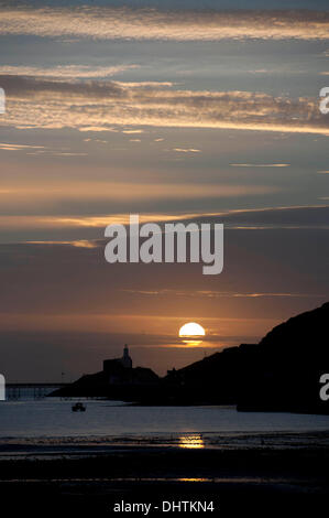 Swansea - UK 15. November 2013: die Sonne geht über den Leuchtturm am Mumbles auf einer klaren Herbstmorgen. Bildnachweis: Phil Rees/Alamy Live-Nachrichten Stockfoto