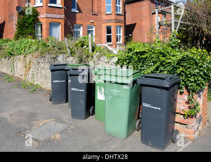 Schwarz (allgemein) und grün (recycling) Mülltonnen auf dem Bürgersteig in Maidstone, England. Stockfoto