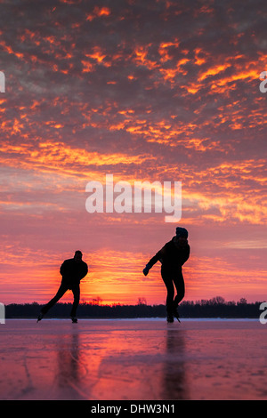 Niederlande, Loosdrecht, Seen genannt Loosdrechtse Plassen. Winter. Eislaufen. Sunrise Stockfoto