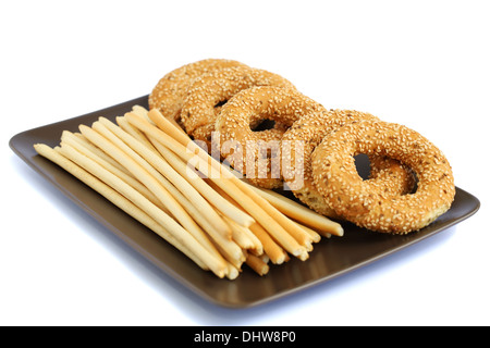 Runder Zwieback und Brot-Sticks auf Platte isoliert auf weißem Hintergrund. Stockfoto