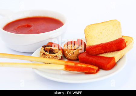 Zwieback mit Sesam, Brot-Sticks und roter Soße auf grauem Hintergrund isoliert. Stockfoto