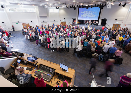 Die Audio-visuelle Kontrolle Kiosk und Gemeinde Teilnahme an zeitgenössischen Anbetungsmusik während Sonntagsgottesdienst in der großen modernen Könige Community Church. Stockfoto