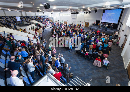 Gemeinde, Teilnahme an zeitgenössischen Anbetungsmusik während Sonntagsgottesdienst in der großen modernen Könige Community Church. Stockfoto