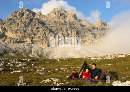 Junge Menschen, camping in den Bergen und Freiheit während des Sonnenuntergangs zu genießen Stockfoto