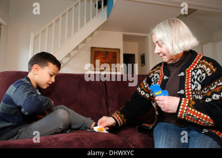 7-Year-Old Boy Spielkarten mit seiner Großmutter Stockfoto